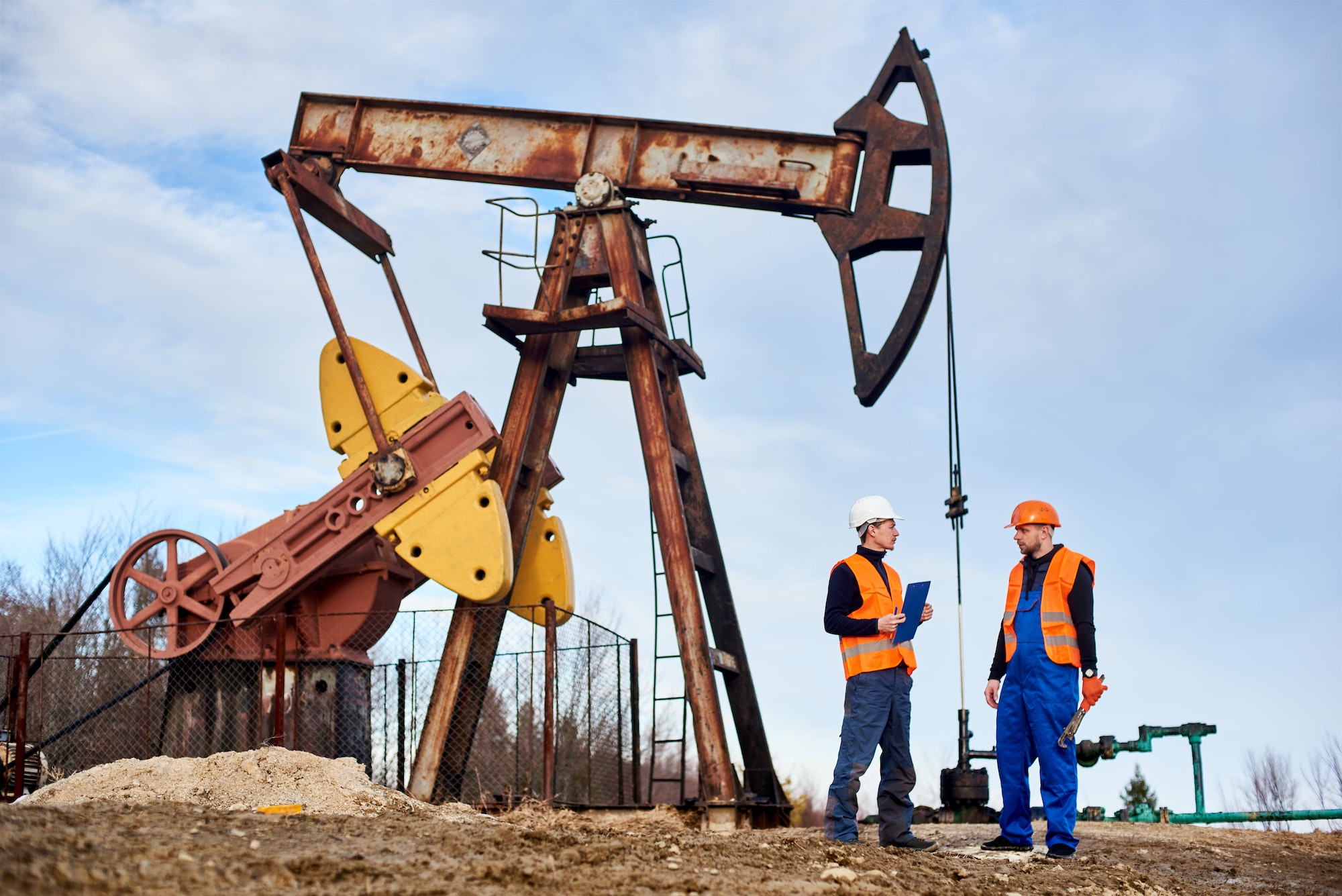 Oil workers discussing project at oil field.